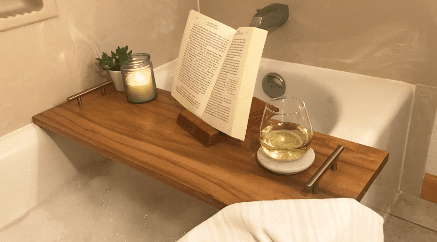 diy bathtub tray set up with win, candle, and book display