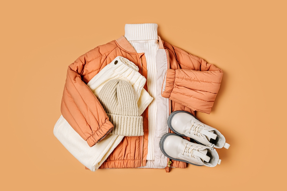 Winer clothes laid out on an orange background